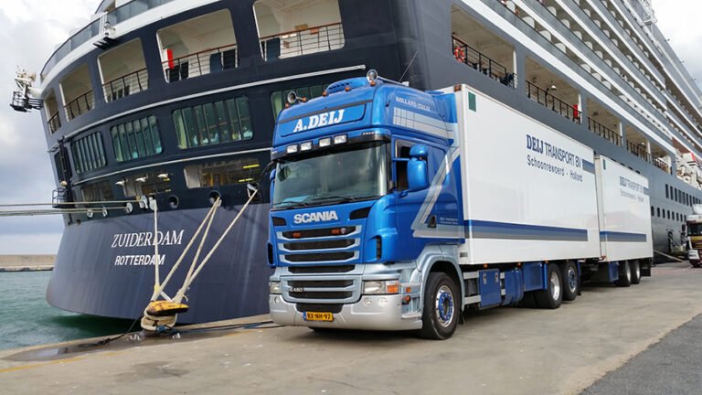 Combinatie van Deij Transport naast een cruiseschip in de haven