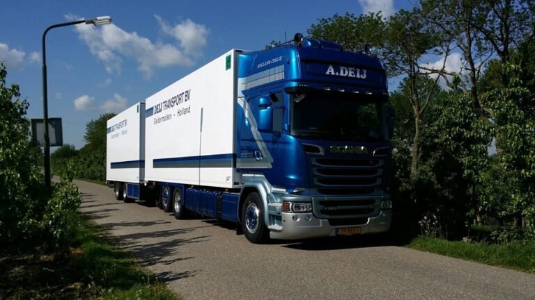 Scania-combinatie van Deij Transport langs een bomenrij